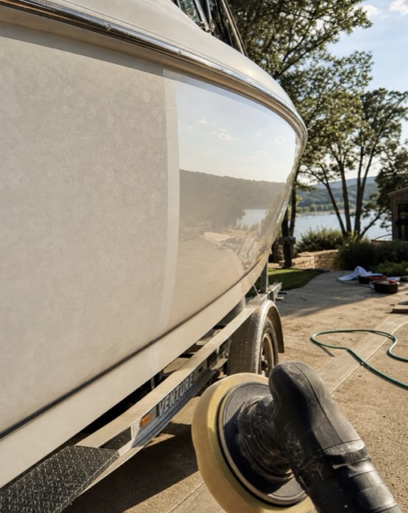 Boat hull mid gelcoat correction near Lake Travis — oxidized side next to polished glossy side