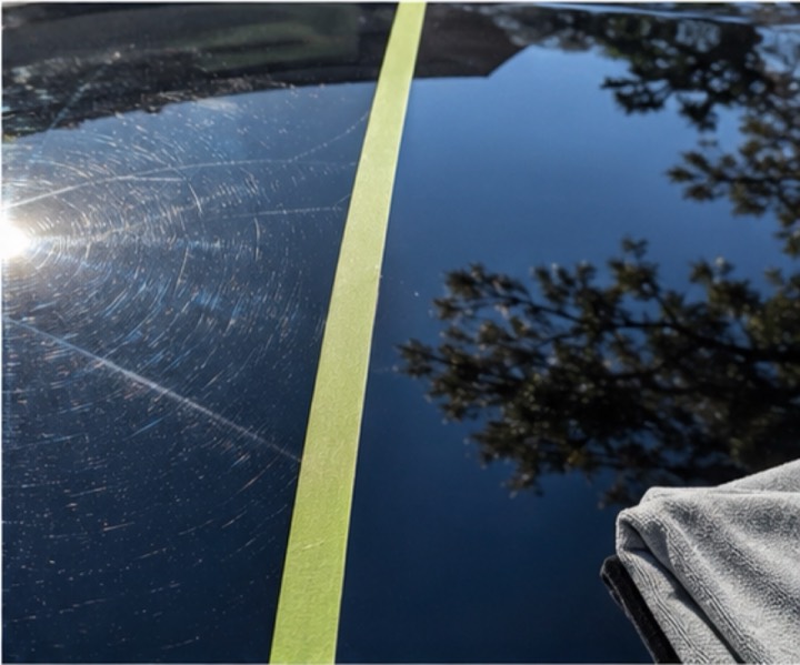 Black hood split by tape: swirled paint on one side, fully corrected mirror gloss on the other